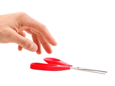 Hand takes red scissors isolated on white backgroundの写真素材