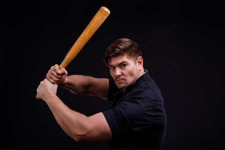 A man is swinging a bat on a black backgroundの写真素材