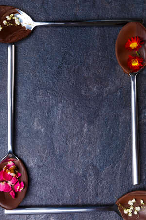 Spoons with frozen chocolate in which the flowers. Spoons in the form of a square close-upの写真素材