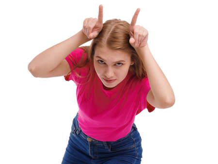 The girl makes the horns on her head with her fingers. Isolated on white background.の写真素材