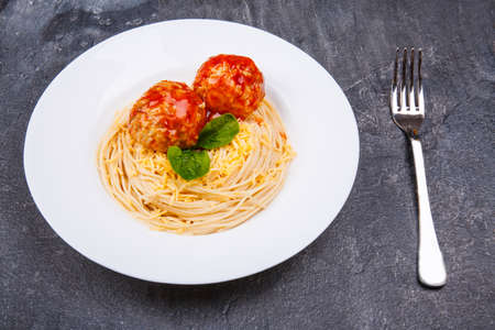 Pasta with cheese and meatballs on a table.の写真素材