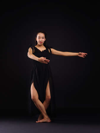 A young dancer is standing in the dance, the pivot position for rotation. On a black background.の写真素材