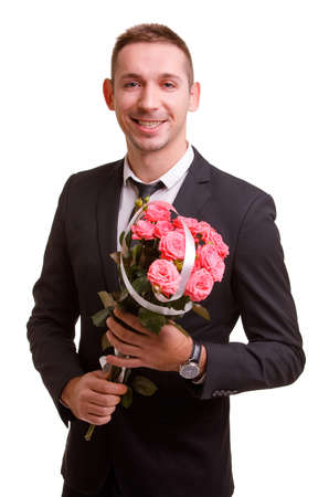 A guy smiles and holds a bouquet in his hands on a white isolated backgroundの写真素材