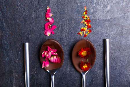 Melted and frozen chocolate on spoons close-up on a stone backgroundの写真素材
