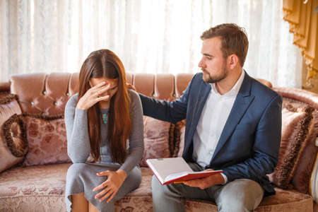 Psychologist speaks with a frustrated girl on the couchの写真素材