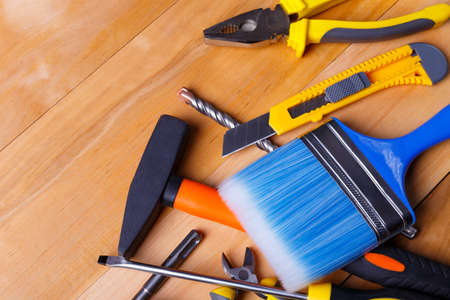 Tool for minor repairs on a wooden background. Top view of a close-up at an angle