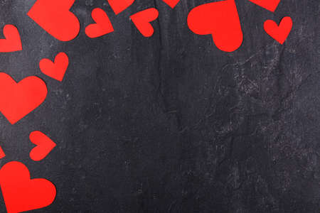 The hearts are red, cut out in different sizes, in a semicircle in the upper left corner on a stone backgroundの写真素材