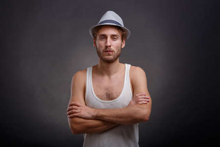 A man in a hat folded his hands against a black backgroundの写真素材