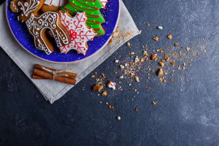 A plate with cookies in the form of a Christmas tree, deer and snowflakes is shown incompletely on a...