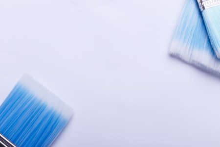 Brushes blue different in size are directed at each other on a white sheet of paper close-upの写真素材