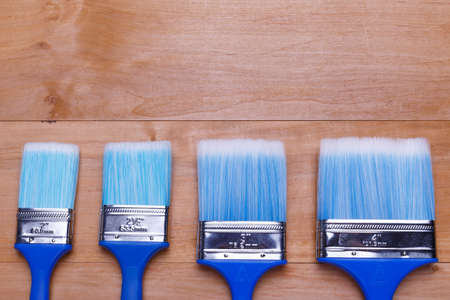 Four different in size blue brushes on a wooden backgroundの写真素材