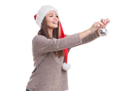 A girl hanging a Christmas toy on a white isolated backgroundの写真素材