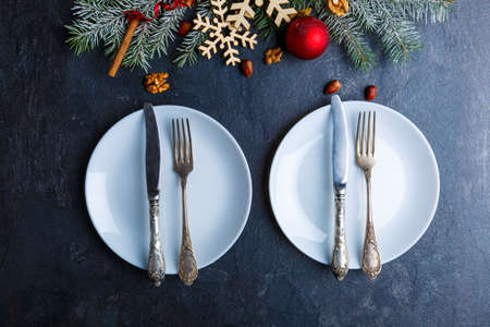 The two plates, next there is Christmas tree with snowflakes, tree toys and nuts. View from above.の写真素材