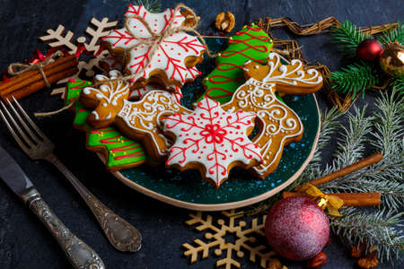 Delicious sweet Christmas gingerbreads in sugar glaze on a festive table set.の写真素材