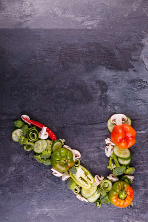 The appetizing inverted digit seven is laid out on the right side, from juicy, appetizing vegetables, Bulgarian pepper, cucumber, broccoli, laid out on a black background, layout, free space for text,の写真素材