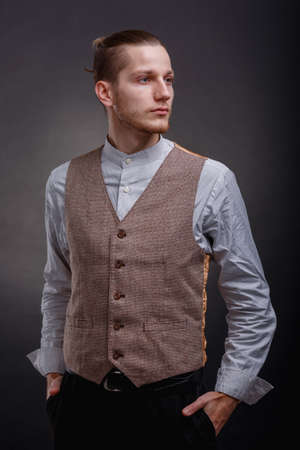 Gangster stands with hands in pockets pockets on a gray backgroundの写真素材