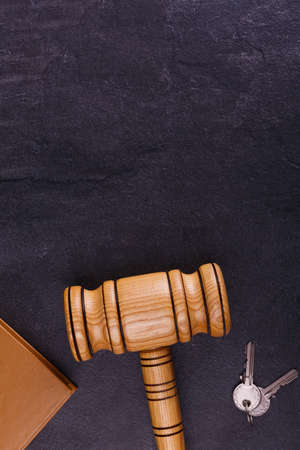 The wooden judge's hammer lies next to the keys and the book. View from aboveの写真素材