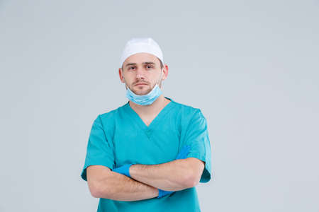 A male doctor in uniform, stands and crossed his arms over his chest. Isolation.の写真素材