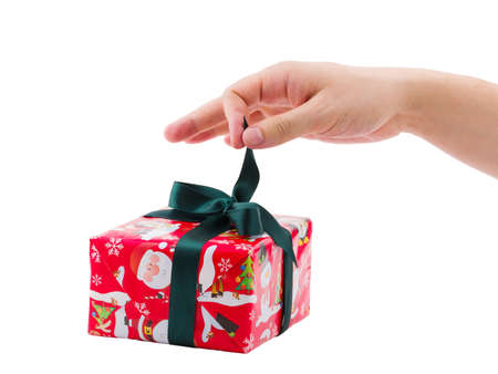 The hand unleashes a bow of a gift box. Isolated on white background.