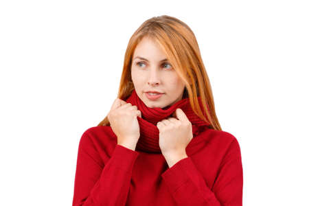 A girl with red hair, holds behind a scarf on her neck, looks away and smiles. Isolated.の写真素材