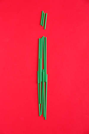 On the red background are laid green tubules in the form of the letter i.の写真素材