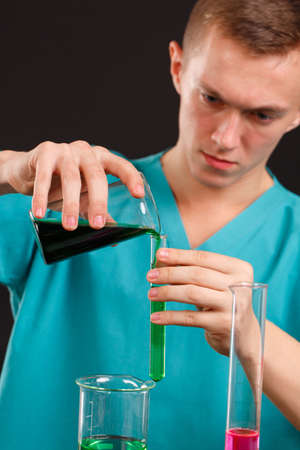 Male scientist mixing reagents close-up on a black background