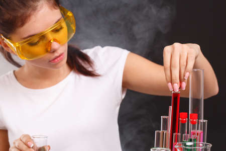 A lab assistant takes out a test tube from a kit on a black backgroundの写真素材