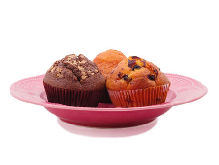 Different cupcakes in a plate on a white isolated backgroundの写真素材