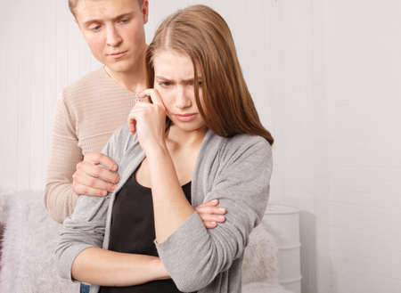 A guy holding an injured girl by the shoulderの写真素材