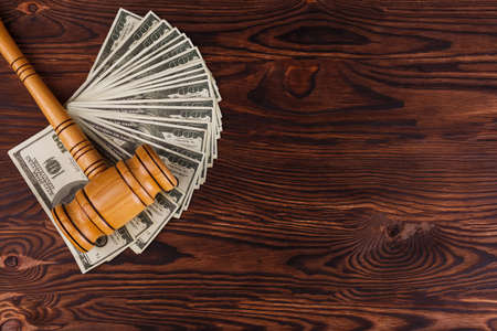 Dollar bills and a auction hammer on a table. Place for the inscription. Details of the auction.の写真素材