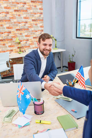 Two office workers shake hands with each other. Inside.の写真素材