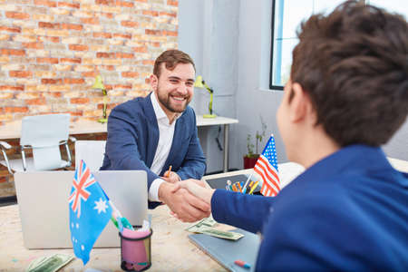 In the office, two men shake hands with each other. Inside the office.の写真素材