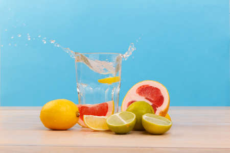 The useful and juicy citrus, next there is a glass with water and a slice of lemon. Side view. Inside.の写真素材