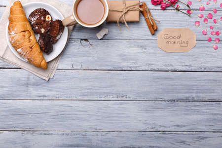 Breakfast, on the table, a croissant with a chocolate cake, on a gray background, a free place for text.の写真素材
