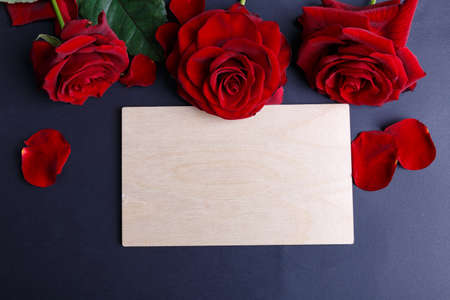 Close-up of red roses on a black background with an envelope on the middle, holiday concept.の写真素材