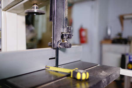 Working jigsaw machine next to a tape measure on a machine on a blurred backgroundの写真素材