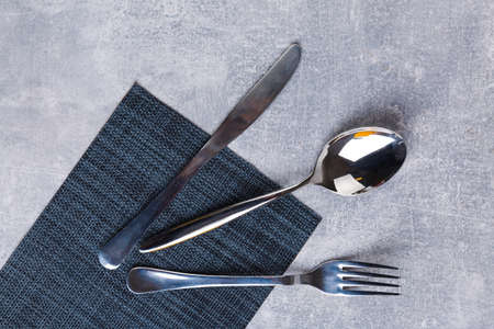 Spoon, fork and knife on a kitchen serving napkin.の写真素材