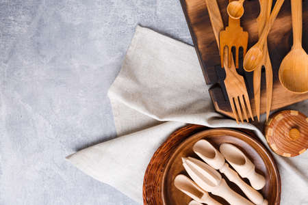 On a background with a place for an inscription are various kitchen utensils made of wood.