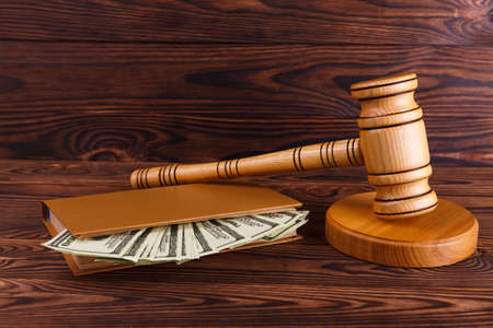 The auctioneers hammer on the stand and a notepad in which a lot of dollar bills.