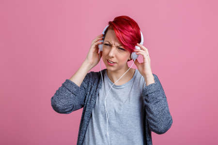 Girl listening to music on headphones, which she does not like.