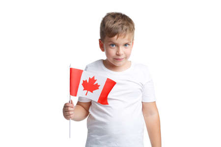 A boy holds a flag of Canada on a stick on a white isolated backgroundの写真素材
