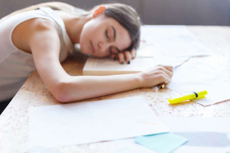 Young girl, asleep at work at the desk with documents.の写真素材