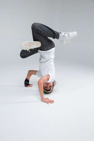 A little boy dancer break dance stands on his head.の写真素材