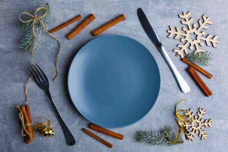 On the table is a plate with cutlery, around which are Christmas decorations.の写真素材