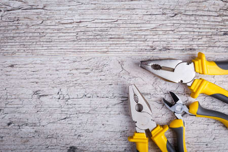 On the wooden surface with a place for an inscription there are pliers and cutters .