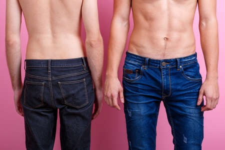 Bared torso of two guys in b jeans, turned in front and back.の写真素材