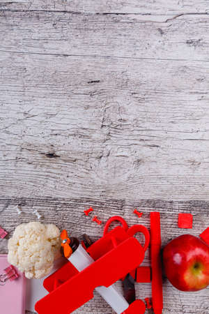Layout of various stationery, a toy airplane, a red apple and a piece of cauliflower. Place for the inscription.の写真素材