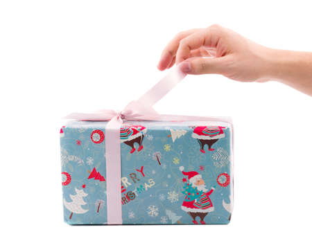 The hand of the European man unfolding a Christmas gift box, packed in blue paper with a festive...
