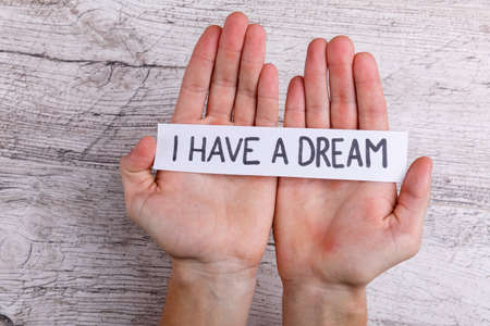 Hands hold a paper sign with the inscription I have a dream.の写真素材