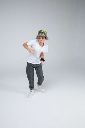 The boy is a teenager is actively dancing with a funny face sculpture.の写真素材